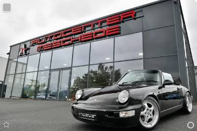 Black Porsche 911 (964) Carrera 4 Cabriolet in front of a dealer in Meschede, Germany