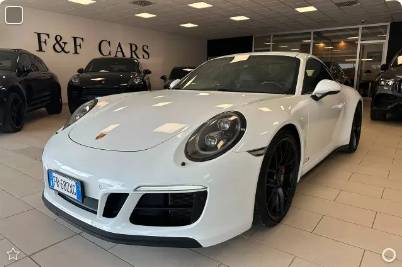 White Porsche 911 (991) Carrera 4 GTS in a showroom in Treviso, Italy